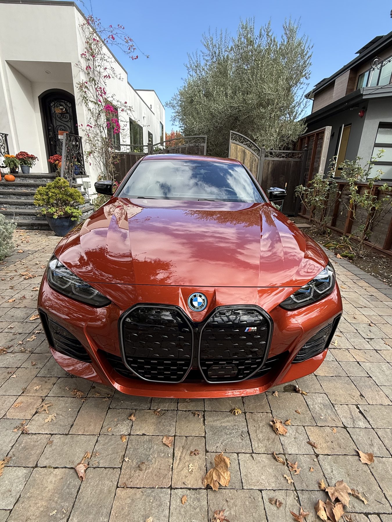 Front view of the Sunset Orange BMW i4 M50 showing the grille